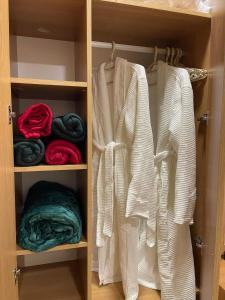 a closet with white shirts and towels in it at 20%off to Bakuriani amenities in Bakuriani