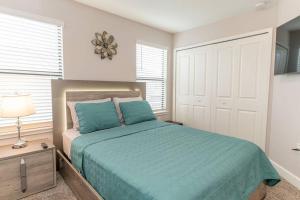 1 dormitorio con 1 cama con sábanas azules y puerta en Resort Style 3/2 Condo :) minutes from Disney!, en Kissimmee