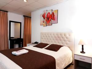 una camera da letto con un grande letto e due quadri alle pareti di HOSTAL MURGEON BOUTIQUE a Quito