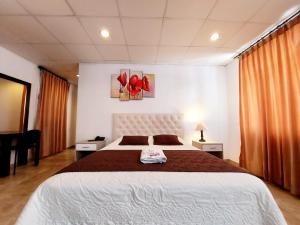a bedroom with a large bed with red shoes on the wall at HOSTAL MURGEON BOUTIQUE in Quito +11 photos