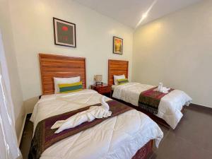 two beds in a room with two at Summer Resort in Kep