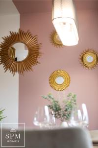 three mirrors on a pink wall with a table at Large 4 Bed House - Long Stays Welcome - Smart TVs in Each Bedroom - Parking - Wifi in Peterborough