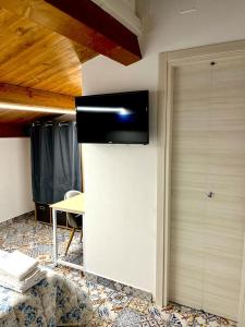 a room with a table and a wall with a television at B&B Donna Francé in Corbara
