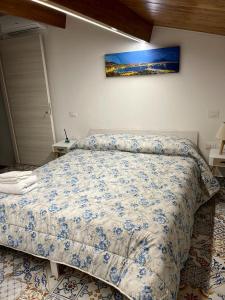 a bedroom with a bed with a blue and white comforter at B&B Donna Francé in Corbara