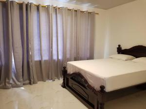 ein Schlafzimmer mit einem Bett und Vorhängen in einem Zimmer in der Unterkunft Apartamento1 bien ubicado en Tuluá in Tuluá