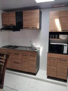 eine Küche mit einer Spüle und einer Mikrowelle in der Unterkunft Apartamento1 bien ubicado en Tuluá in Tuluá