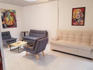 a living room with a couch and chairs and a table at Apartamento1 bien ubicado en Tuluá in Tuluá