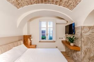 um quarto com uma cama branca e uma janela em Parco Ducale Design Rooms em Parma