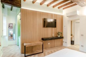 a living room with a tv on a wall at Parco Ducale Design Rooms in Parma