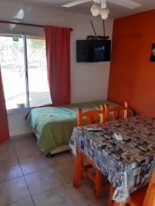 Habitación con mesa, cama y ventana en Antiguo Molle en Merlo