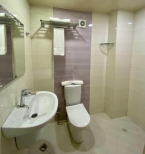a bathroom with a white toilet and a sink at Nizami Street Hotel in Baku