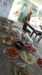 ein Tisch mit vielen Teller Essen drauf in der Unterkunft Hotel Caieiras in Guaratuba