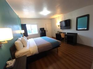 Habitación de hotel con cama y escritorio en Othello Inn And Suites en Othello