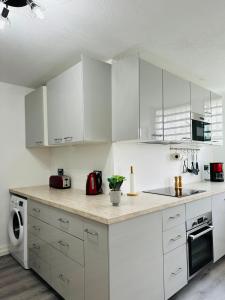 DucosSAB Location - Appartement的配有白色橱柜和台面的厨房
