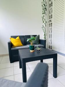 a black coffee table in a living room with a couch at SAB Location - Appartement in Ducos