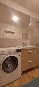 a laundry room with a washer and a sink at Uroczy apartament parking gratis Pogórze obok Gdynia in Pogórze