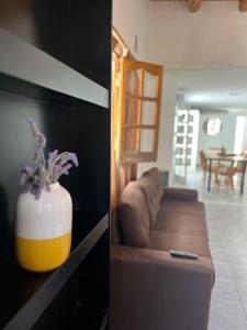 sala de estar con sofá y jarrón con flores en Complejo Lamadrid - semiprivado en Luján de Cuyo