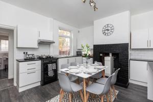 a white kitchen with a dining table and chairs at Spacious three bedroom property! in Hemsworth