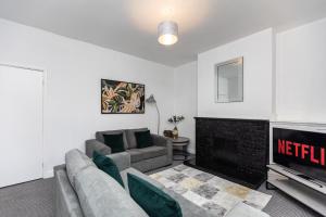 a living room with a couch and a fireplace at Spacious three bedroom property! in Hemsworth