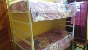 a bunk bed in a room with a bed and a pillow at Hermosa vista, casa en Boquete. in Boquete