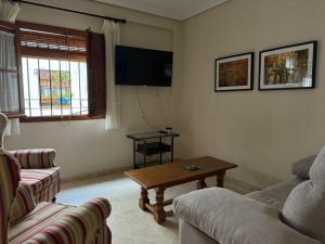 een woonkamer met een bank en een salontafel bij Apartamento Buen Pastor con parking gratuito in Córdoba
