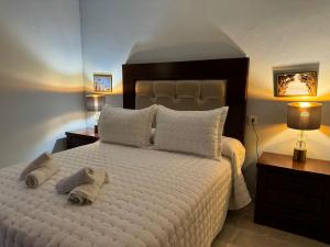 een slaapkamer met een groot wit bed en handdoeken bij Apartamento Buen Pastor con parking gratuito in Córdoba