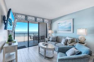 a living room with a couch and a table at Ideally situated beachfront condo with pool and views in Marco Island