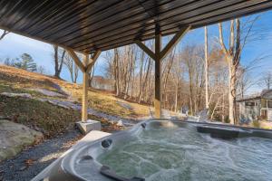 a hot tub under a gazebo at Fairway Lodge On One in Beech Mountain