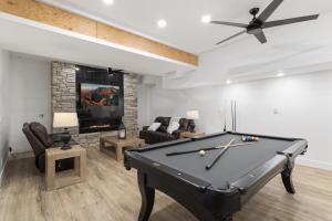 a pool table in a living room with a ceiling fan at Fairway Lodge On One in Beech Mountain