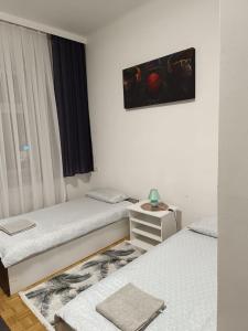 Habitación con 2 camas y una foto en la pared. en Wohnung in der nähe Wiener Stadthalle und Zentrum, en Viena