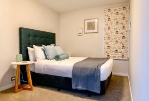 a bedroom with a large bed with a green headboard at Lake Pukaki Lake House in Lake Pukaki