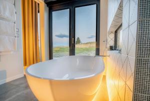 a large tub in a bathroom with a large window at Lake Pukaki Lake House in Lake Pukaki
