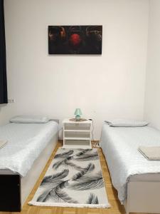 Habitación con 2 camas y mesa con una foto en la pared. en Wohnung in der nähe Wiener Stadthalle und Zentrum, en Viena