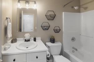 Un baño con lavabo, inodoro y espejo. en Salt Lick Sanctuary, en Silverthorne 20 fotos más