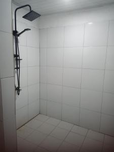a bathroom with a shower with white tiles at Renata Cottages in Ohoililir