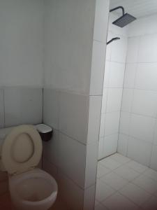 ein weißes Bad mit einem WC und einer Dusche in der Unterkunft Renata Cottages in Ohoililir