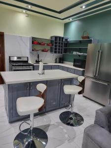 a kitchen with a counter and two bar stools at The Royal at Meadowbrook. in Kingston