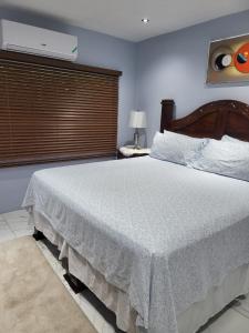 a bedroom with a large bed with a white blanket at The Royal at Meadowbrook. in Kingston