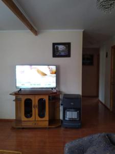 sala de estar con TV de pantalla plana en un soporte de madera en Casa en algarrobo, en Algarrobo