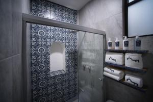y baño con ducha, espejo y toallas. en Casa de los Frailes, en Oaxaca City