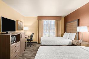 a hotel room with two beds and a flat screen tv at Bitterroot River Inn and Conference Center in Hamilton