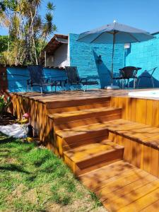 a wooden deck with chairs and an umbrella at Hostel Trem Di Durmi in Belo Horizonte