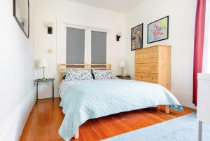 a bedroom with a bed and a dresser and two windows at Private room in the heart of Elmwood Berkeley! in Berkeley