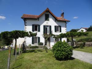 a white house with black windows and a fence at Etchevers-enia in Suhescun +16 photos