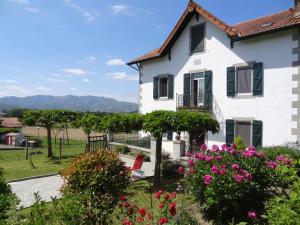 a white house with flowers in front of it at Etchevers-enia in Suhescun