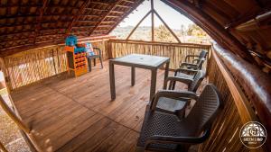 un porche con sillas y una mesa en una cabaña en Greenlandomesa Zafiro, en La Honda