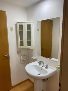 ein weißes Badezimmer mit einem Waschbecken und einem Spiegel in der Unterkunft Departamento Centrico 2 dormitorios in Neuquén