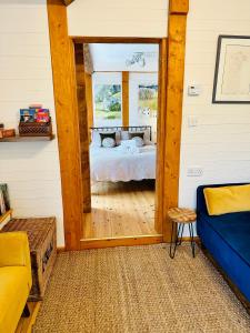 ein Schlafzimmer mit einem Bett und einem Spiegel in einem Zimmer in der Unterkunft The annex on our farm in Colwyn Bay