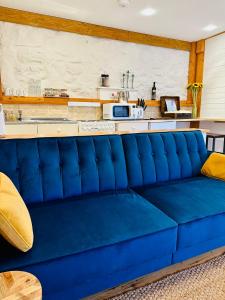a blue couch in a room with a kitchen at The annex on our farm in Colwyn Bay