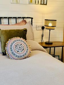 a bed with a pillow and a lamp on a table at The annex on our farm in Colwyn Bay